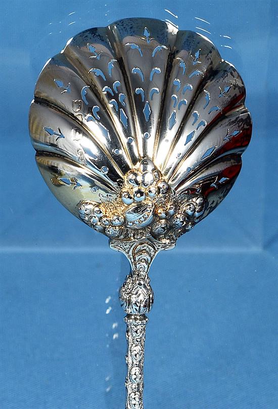 A cased set of four Victorian silver parcel gilt fruit serving spoons and a sugar sifter, spoon 197mm, weight 12.4oz/388 grms.